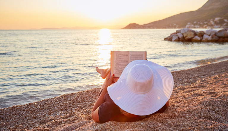 Frau mit Buch am Strand