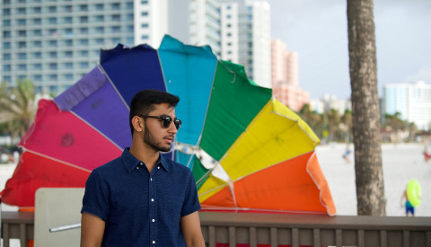 Mann vor Regenbogenschirm