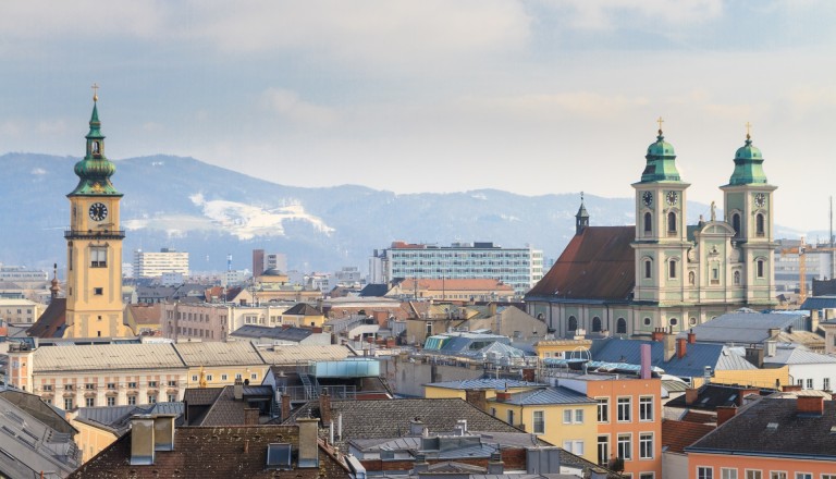 Die hübsche Altstadt von Linz mit den Alpen im Hintergrund.