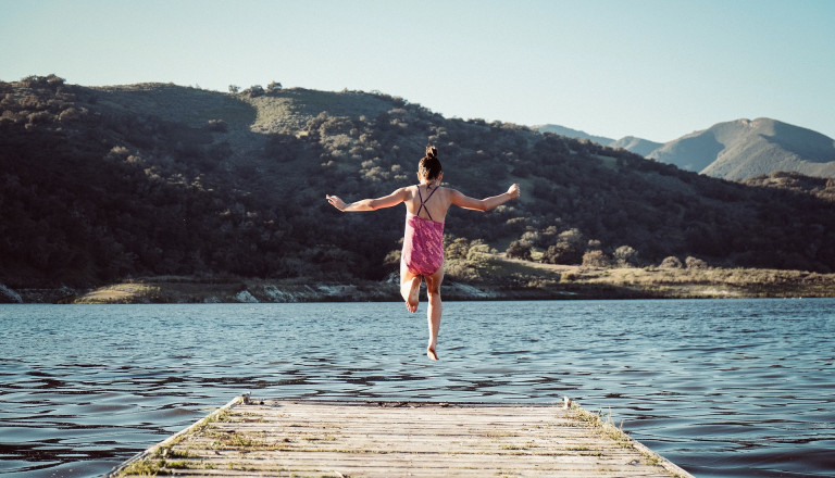 Mädchen springt in den See